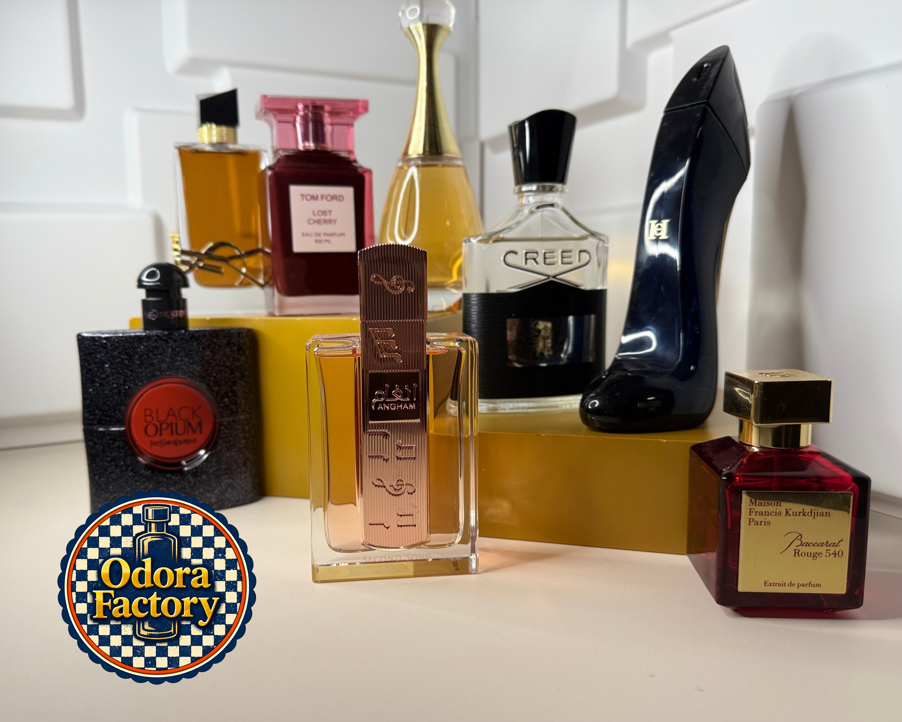 Collection of perfume bottles on a white surface with 'Odor Factory' logo.